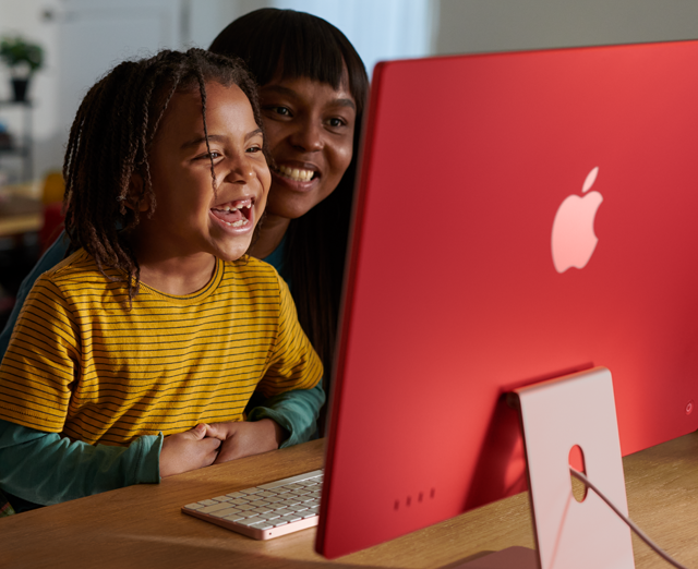 Family members laughing together while watching a show on iMac.